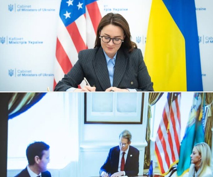 Ukrainian and American flags against the backdrop of the signed Memorandum