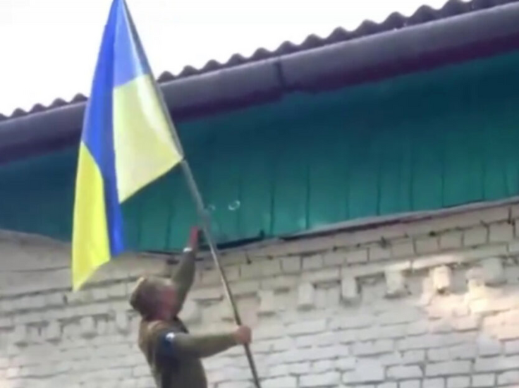 Ukrainian soldiers raise the flag over the city